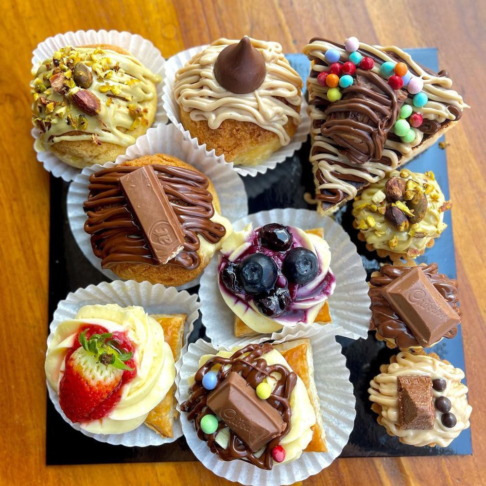 Assorted Yummniesbake desserts: pistachio cheesetarts, Nutella and KitKat brownies, blueberry and strawberry cream pastries